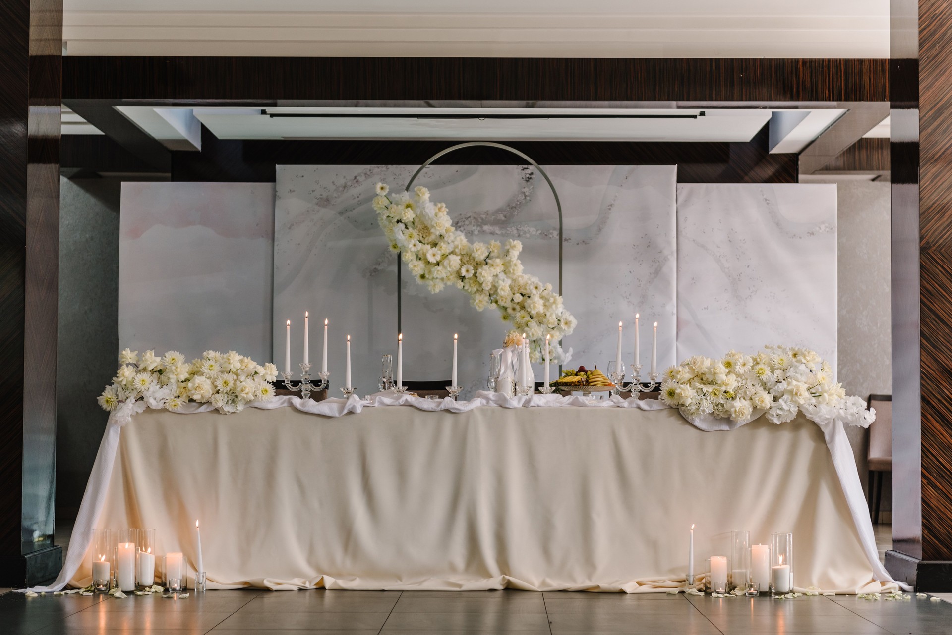 Boda. Arco festivo decorado composición flores y velas en el restaurante salón. La mesa de los recién casados cubrió un mantel en el área del banquete en la fiesta de bodas. Cubierto. Concepto de celebración.